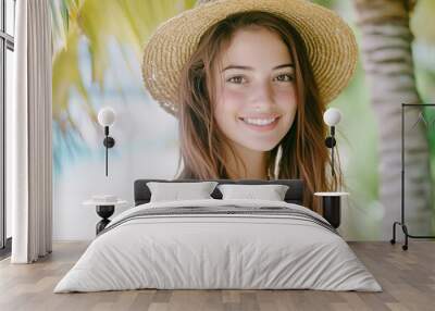 Serene summer portrait of smiling woman wearing straw hat Wall mural