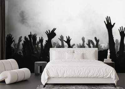 Silhouettes of people with hands raised in a crowd, possibly at a concert or gathering, monochrome image. Wall mural