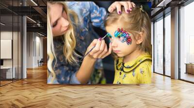 Visagist painting the face of a little girl Wall mural