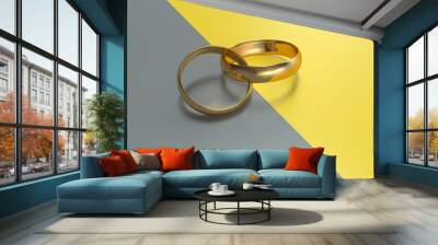 Two gold wedding rings intertwined on a gray and yellow background. Wedding. Wall mural