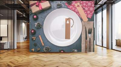 Christmas concept, postcard, gift box, Christmas toys and cones, on a grey background, lined around a white plate Wall mural