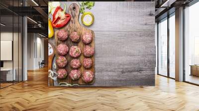 Ingredients for cooking meat balls with herbs and onions on a cutting board with tomatoes, peppers, zucchini and herbs on wooden rustic background top view border ,place for text  Wall mural