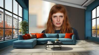 young redhead caucasian woman serious face outdoor portrait Wall mural