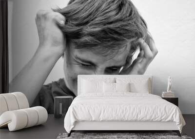 Young man in depression covers his face with his hands Wall mural