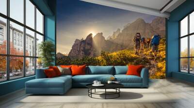 Some hikers go up a mountain path in the early hours of the day Wall mural