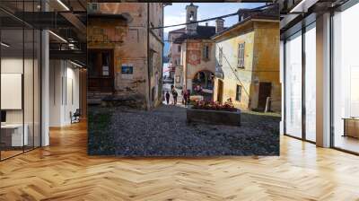 Some tourists go down the main street of the picturesque historical village of Orta, on the lake of Piedmont in Italy. Wall mural