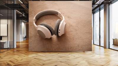 White headphones for listening to music lying on the bed. Wall mural