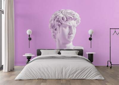 Ancient statue is head of David on purple background. Wall mural