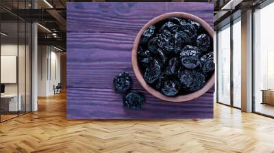 Clay bowl filled with juicy prunes Wall mural