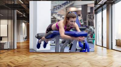 Young model girl makes exercises at the gym in front of mirror Wall mural