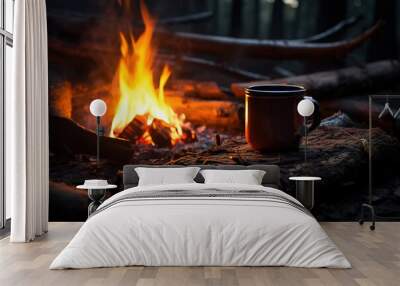 Close-up of a mug standing near a burning fire in the night forest. Hike concept Wall mural