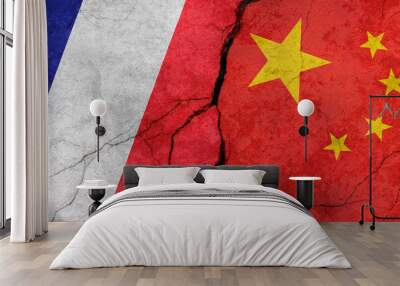 Flags of France and China, concrete wall texture with cracks, grunge background, military conflict concept Wall mural