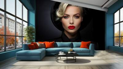 Portrait of beautiful elegant caucasian blonde woman with make-up and red lipstick wearing black hat on dark background looking at camera Wall mural