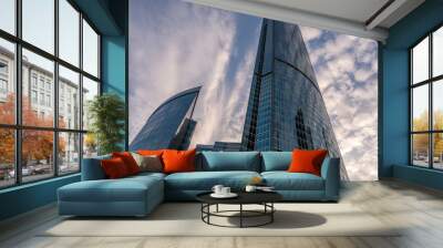 Angled view of modern skyscrapers in business district against blue sky. Looking Up high-rise office buildings. Wall mural