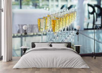 Elegant glasses with champagne standing in a row  Wall mural