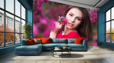 Happy beautiful young woman in spring blossom park.  Wall mural