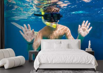 Boy in swimming mask dive in Red sea near yacht Wall mural