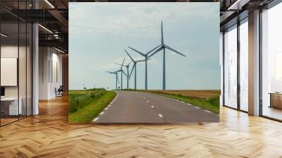 Wind turbines of a power plant for electricity generation close to country road in Normandy, France. Countryside landscape. Environmentally friendly electricity production Wall mural