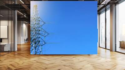 High voltage line pole against blue sky with sunlight. Place for text. Wall mural