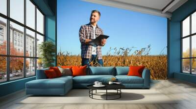 Agronomist inspects soybean crop in agricultural field - Agro concept - farmer in soybean plantation on farm. Wall mural