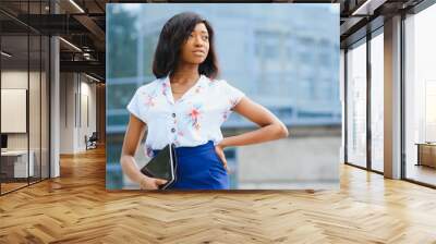 Beautiful black woman using tablet computer in urban background. Successful woman concept. Wall mural