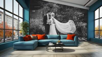 Bride and groom kissing outdoors. Black and white photo. Wall mural