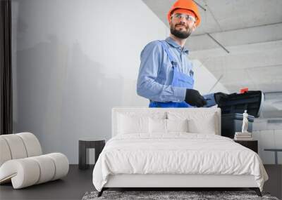 builder on construction site with tool box Wall mural