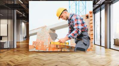 construction mason worker bricklayer installing red brick with trowel putty knife outdoors. Wall mural