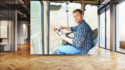 Farmer driving combine and harvesting crop. Wall mural