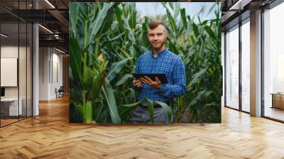 Farmer researching plant in Corn farm. Agriculture and scientist concept. Wall mural