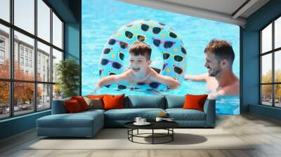 Father and son having fun in swimming pool. Family vacation Wall mural