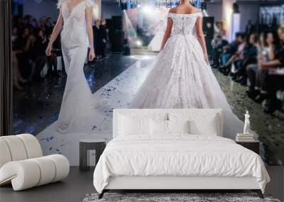 Female models walk the runway in beautiful stylish white wedding dresses during a Fashion Show. Catwalk event showing new collection of clothes. Wall mural