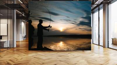 Fisherman at sunset on the river .Beautiful summer landscape with sunset on the river. Fishing. spinning at sunset. Silhouette of a fisherman Wall mural