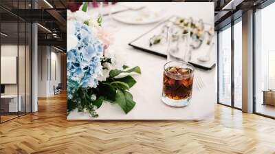 Glass of scotch, whiskey with ice cubes on a rustic festive table, copy space in the background. Closeup, drinks. Wall mural