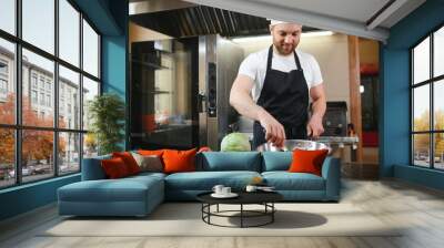 Gourmet chef in uniform cooking in a commercial kitchen Wall mural