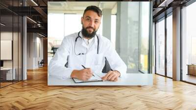 Handsome hispanic doctor man wearing stethoscope at the clinic with a happy and cool smile on face. Lucky person. Wall mural