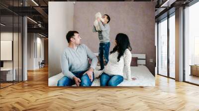 Happy family. Husband, pregnant wife and son at home. Wall mural