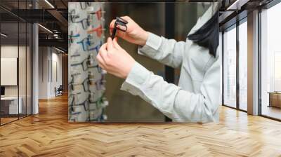 health care, eyesight and vision concept - happy woman choosing glasses at optics store Wall mural