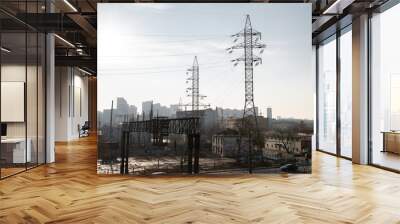 high voltage tower against a blue sky and city background Wall mural