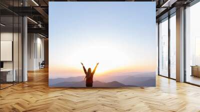 Hiker woman standing with hands up achieving the top. Girl welcomes a sun. Successful woman hiker open arms on sunrise mountain top. Magic pink rhododendron flowers on summer mountains Wall mural