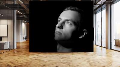 black and white dramatic portrait of a guy close-up on a black background with one light source Wall mural