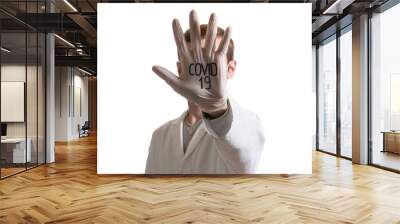 palm in a medical glove in the face with the abbreviation COVID-19 Wall mural