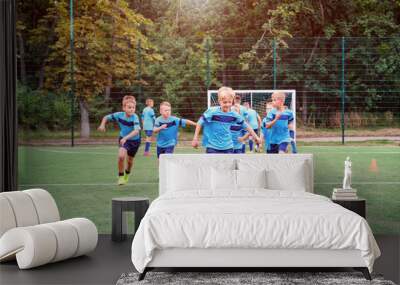 Kids running and kicking soccer balls on children football training session and improving game skills Wall mural