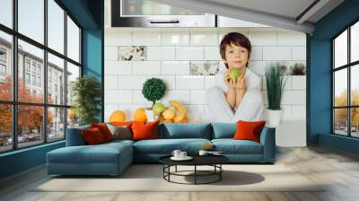 Little boy in the kitchen with a bowl of fresh fruits Wall mural