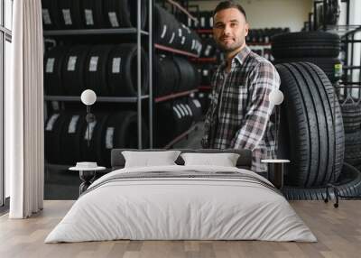 Man chooses winter car tires in the auto shop Wall mural