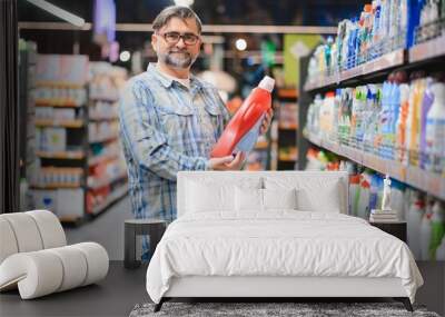 Man in the supermarket in the household chemicals department Wall mural