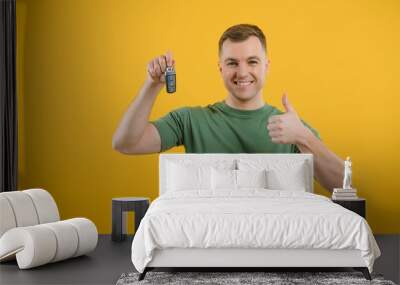 man with car keys on a yellow background, buying a new car Wall mural