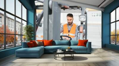 Man working at warehouse and driving forklift Wall mural