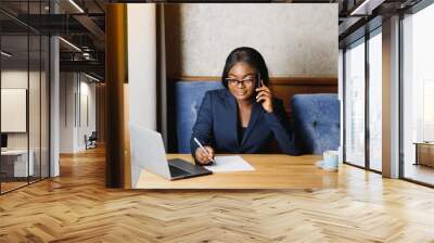 Pensive black businesswoman using tablet computer in coffee shop Wall mural