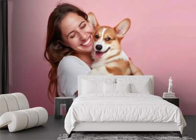 Pets On Plane. Cute brunette woman embracing corgi puppy on pink background Wall mural